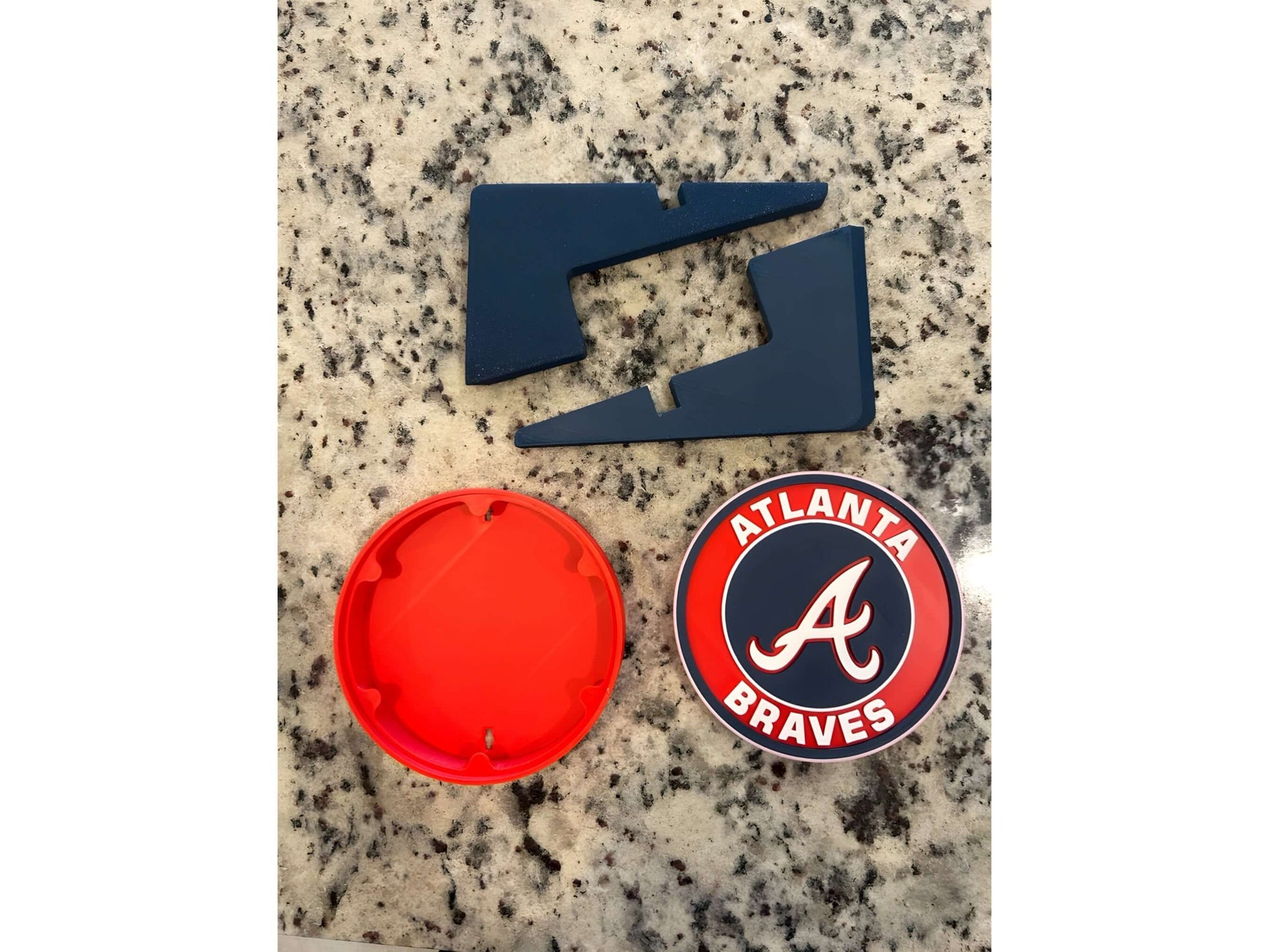 Atlanta Braves 3D printed logo plaque pieces on a granite surface, showcasing vibrant colors and no assembly required.