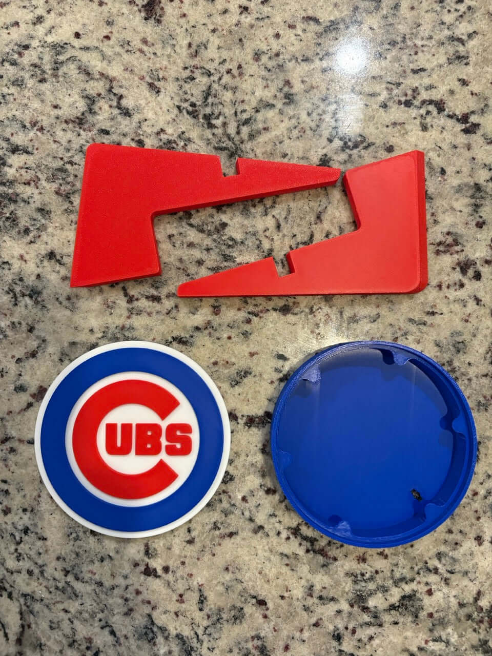 Chicago Cubs 3D plaque components: red pieces and circular Cubs logo on a countertop.