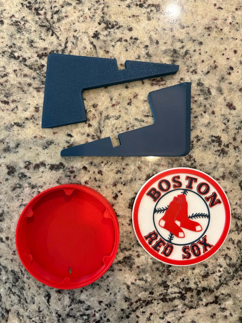 Customized Boston Red Sox 3D printed logo pieces in vibrant colors on a granite countertop.