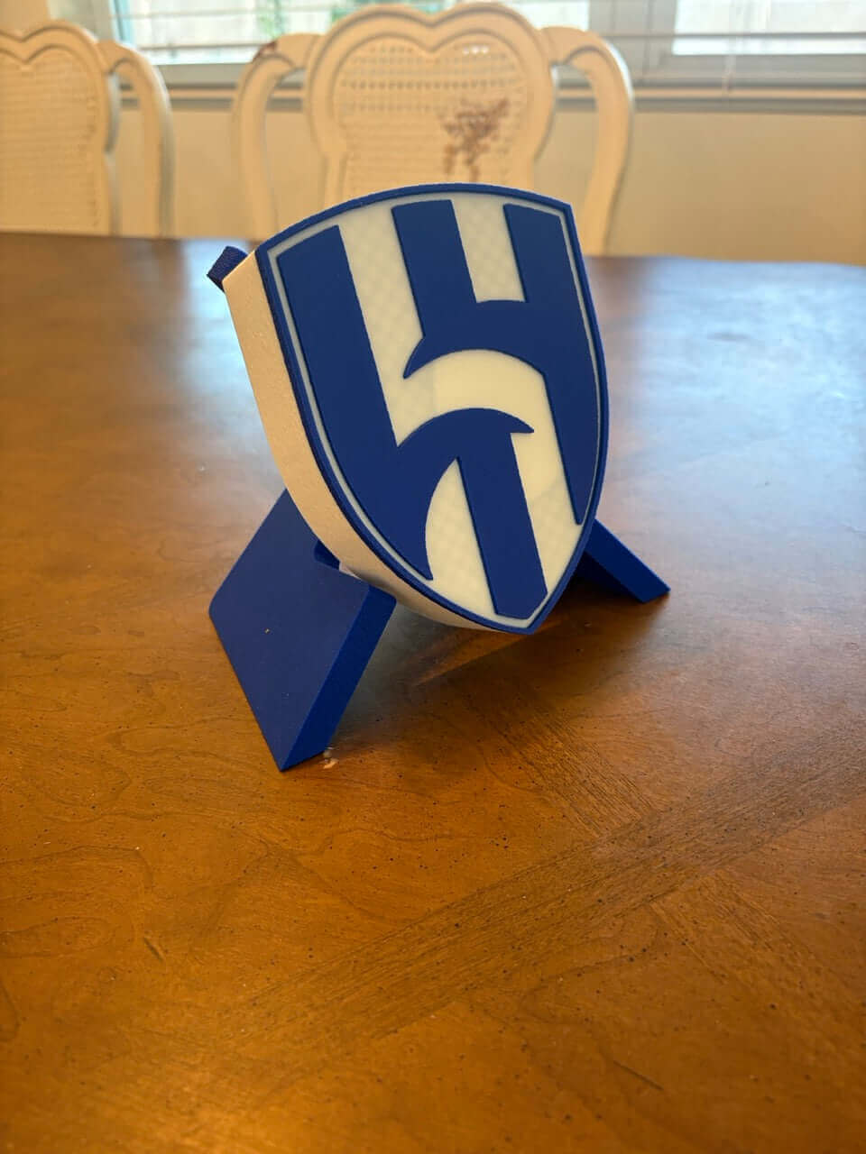 3D printed Al Hilal FC plaque on a wooden table, showcasing vibrant blue and white colors.