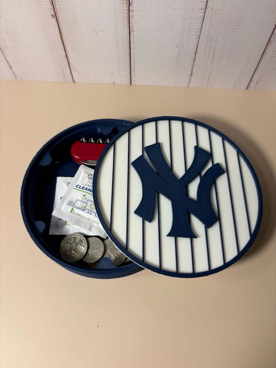 NY Yankees 3D logo stash box with coins and items inside, showcasing vibrant colors and unique design for baseball fans.