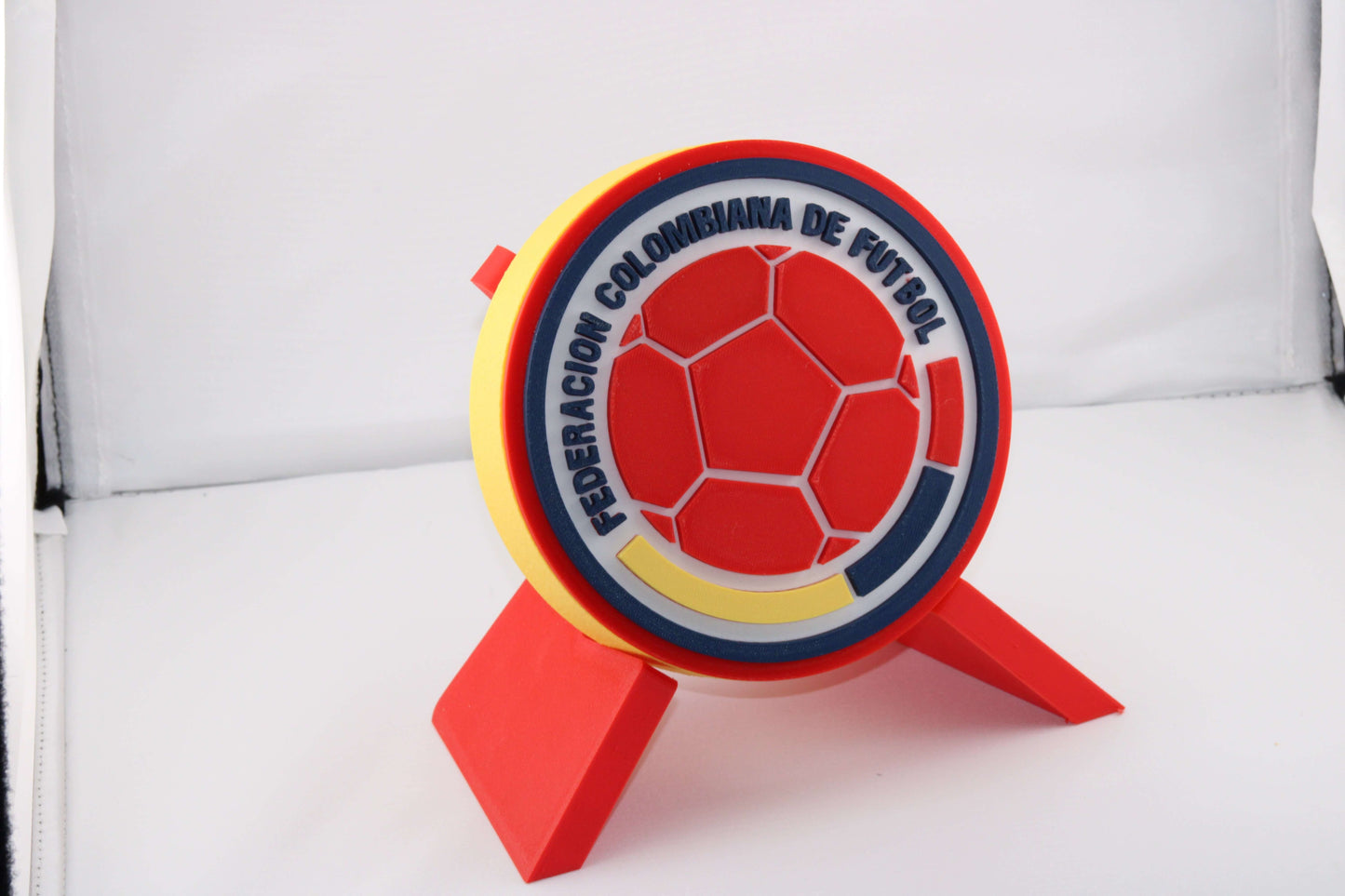3D printed Colombia soccer emblem on a stand, showcasing vibrant colors and unique design for true Cafeteros fans.