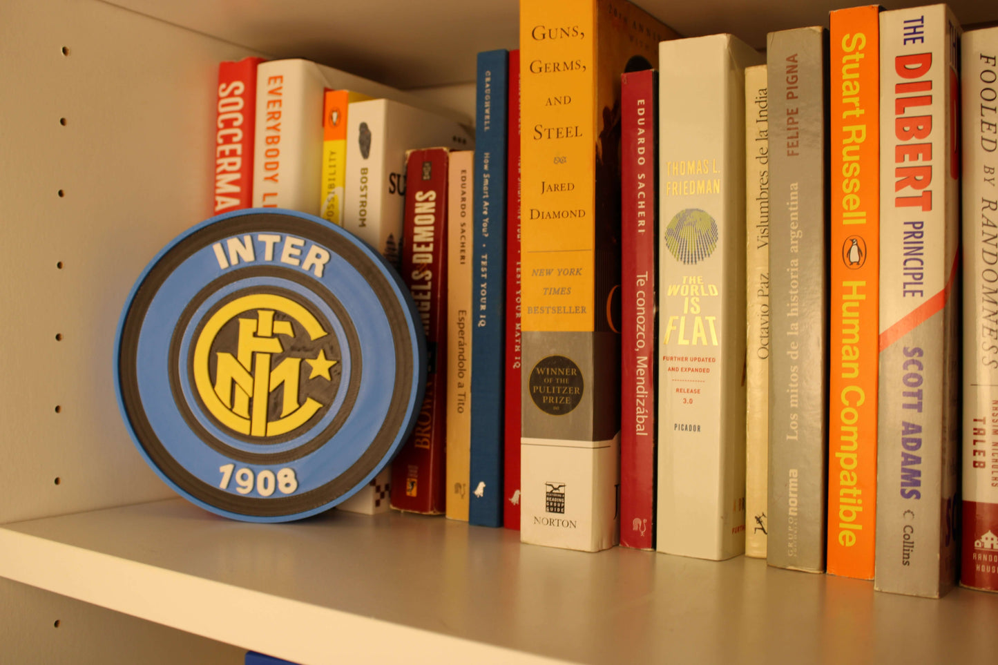 Inter Milan Retro 3D Printed Emblem displayed on a bookshelf, showcasing vibrant colors and unique design for true fans.