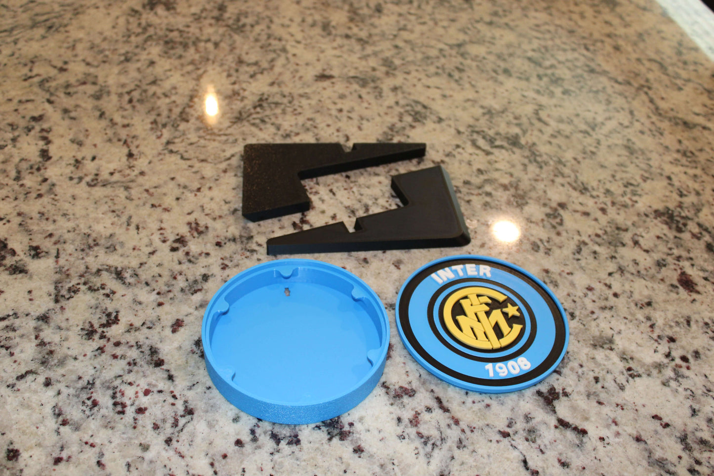 Inter Milan Retro 3D Printed Emblem pieces on granite surface, showcasing vibrant colors and unique design for fans.
