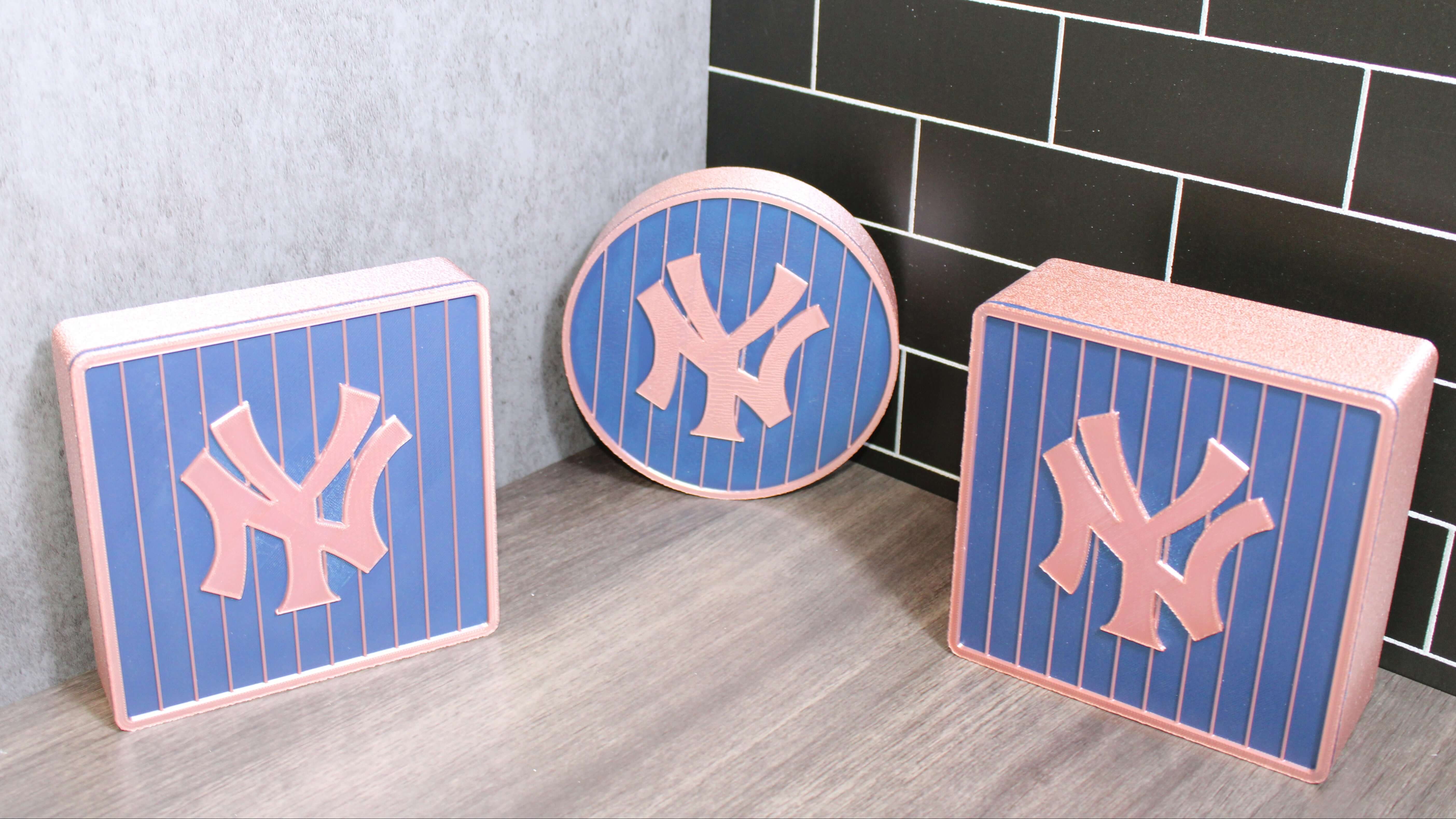 Three decorative items with New York Yankees logo on a tiled floor.