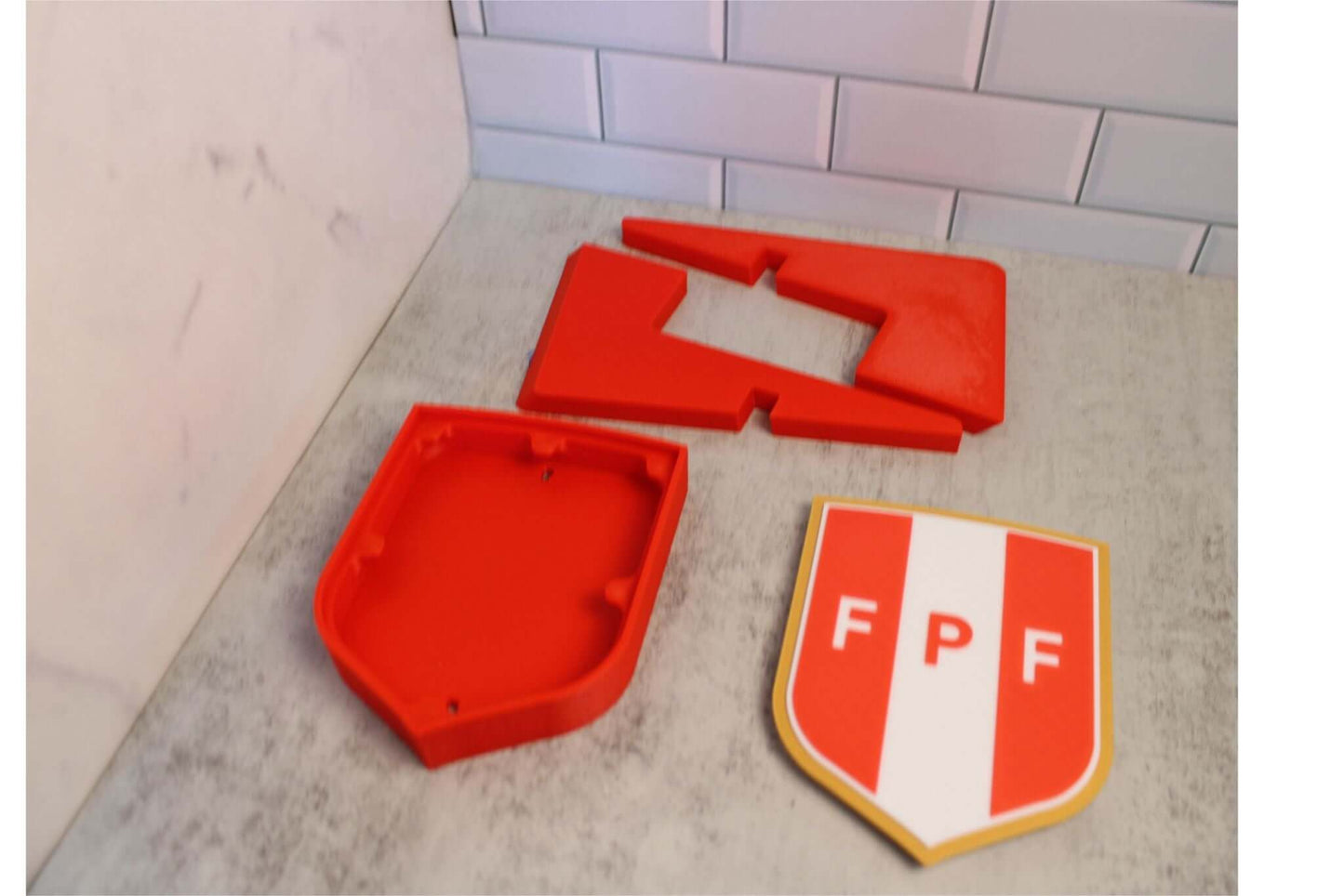 3D printed Peruvian Football Federation plaque pieces in vibrant colors, showcasing unique design and high-quality materials.