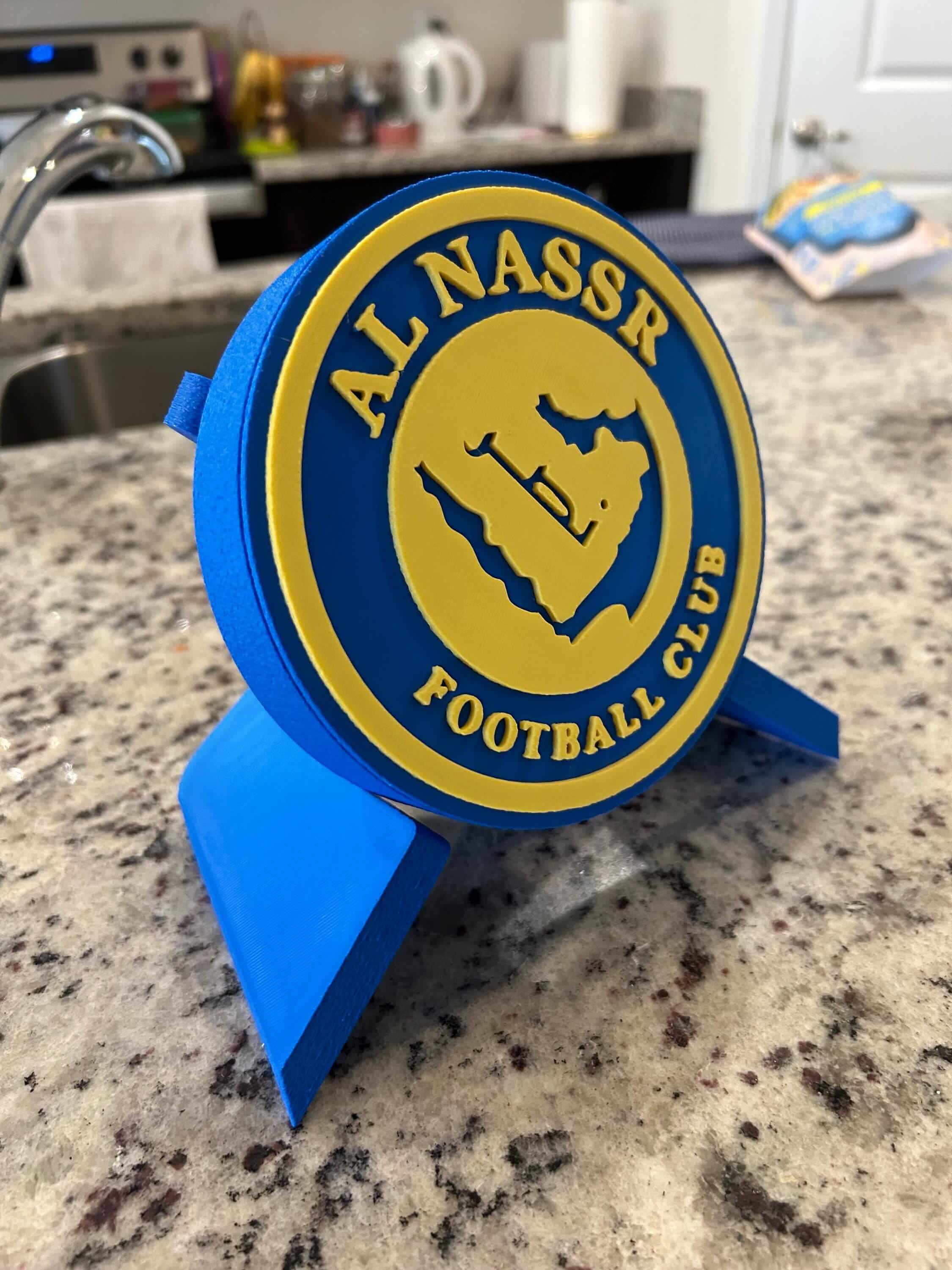 3D printed Al Nassr FC plaque in blue and yellow, showcasing a vibrant logo for passionate soccer fans.