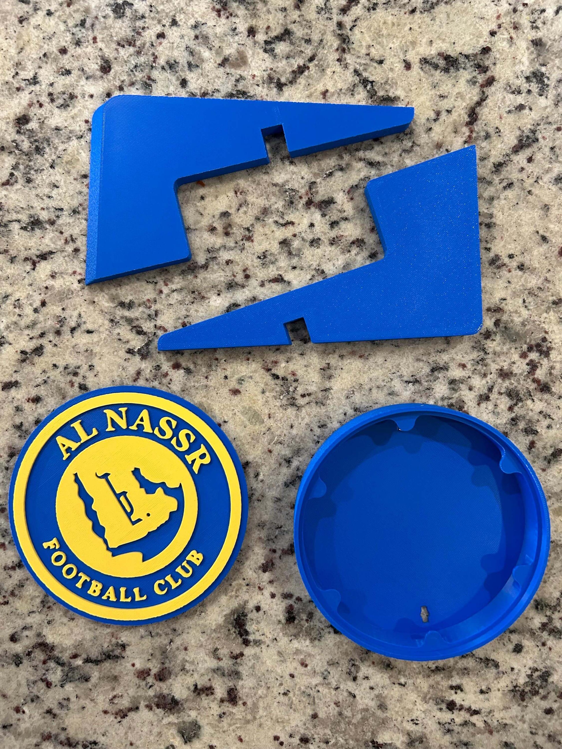 3D printed Al Nassr FC emblem and parts in vibrant blue; a unique collectible for soccer fans.
