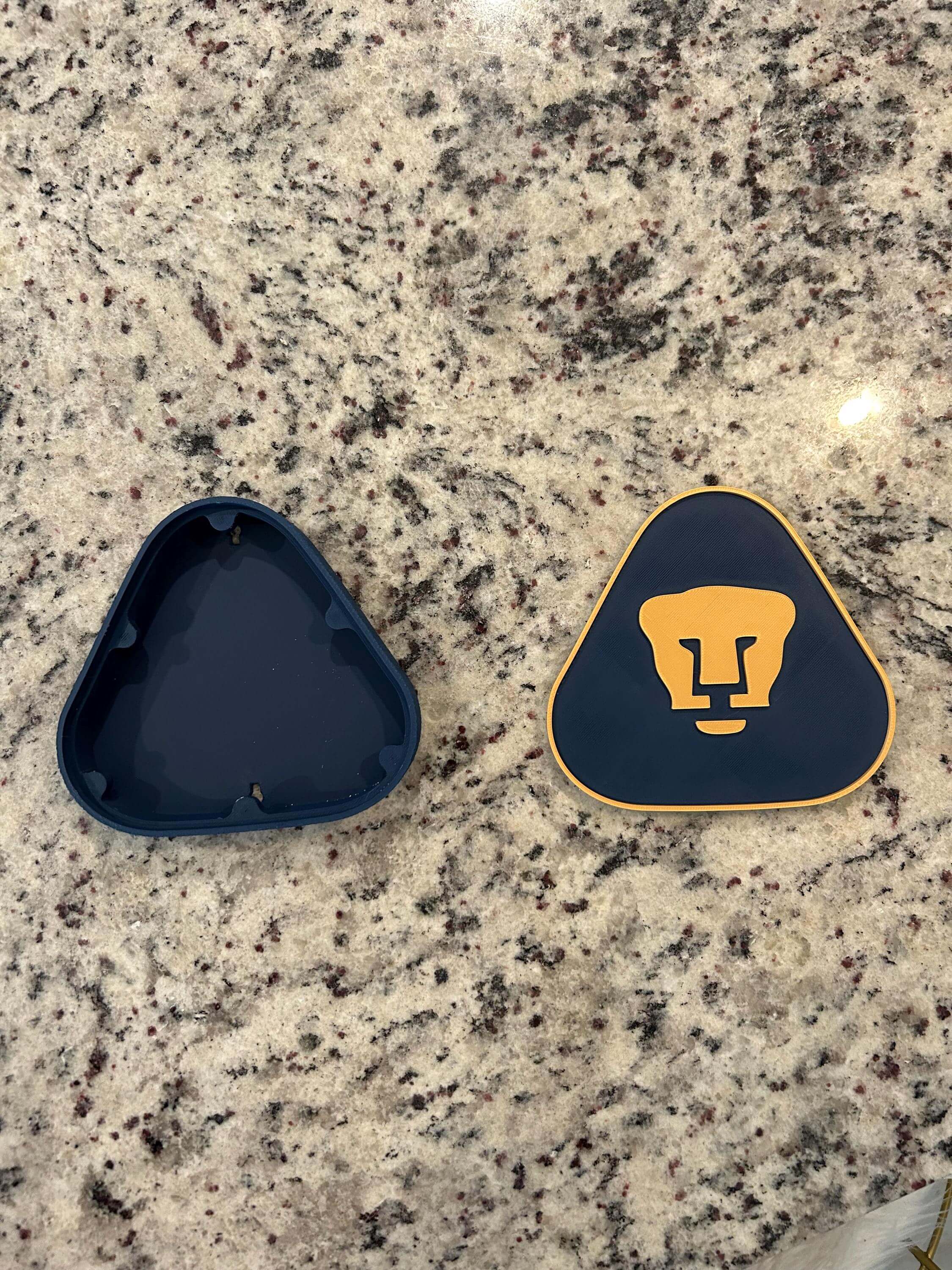 Pumas UNAM 3D printed plaque halves showcasing vibrant colors and iconic soccer shield design on a granite surface.