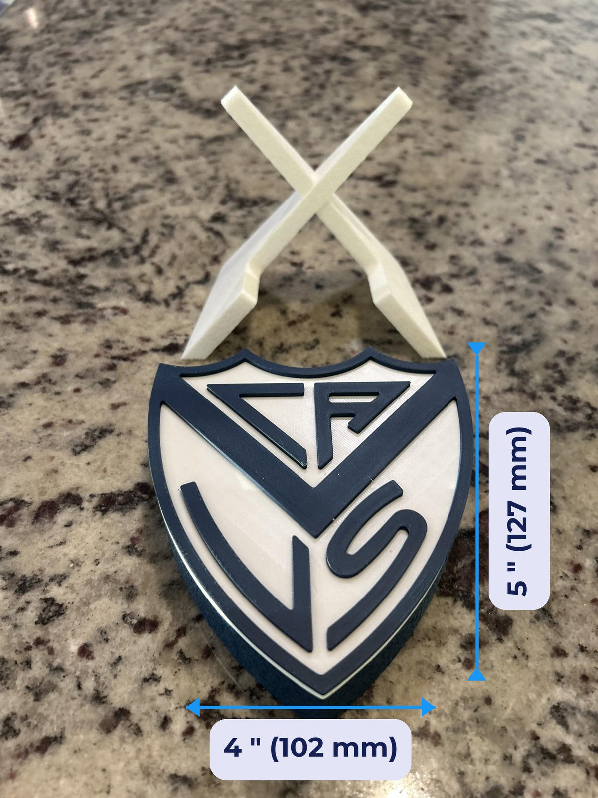 Size guide: Velez Sarsfield 3D printed escudo crest approx 5 inches (127 mm) tall and 4 inches (102 mm) wide on the stand