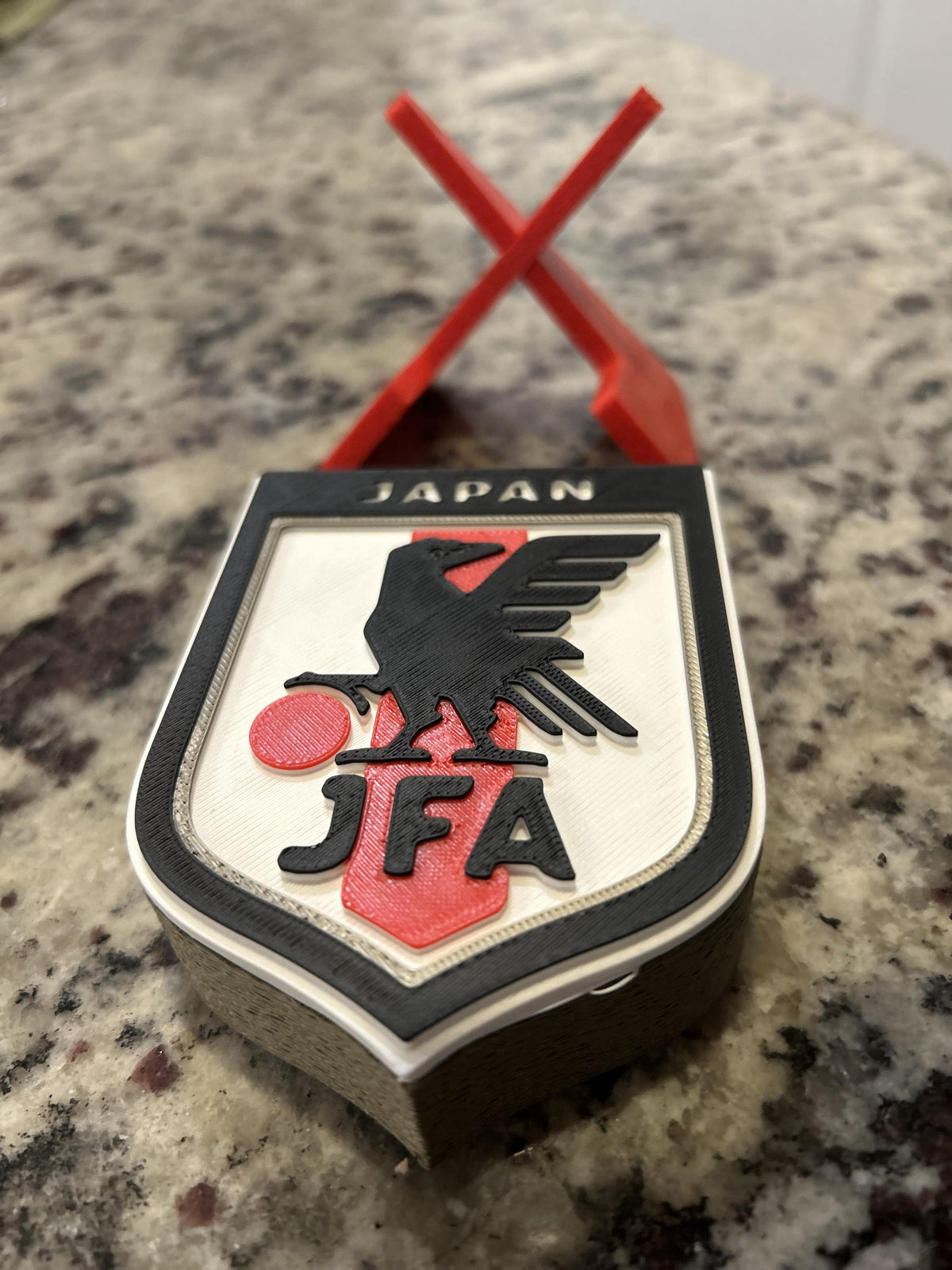 Japan JFA 3D printed shield crest display with red stand and hidden stash box, Samurai Blue soccer fan gift, made in USA