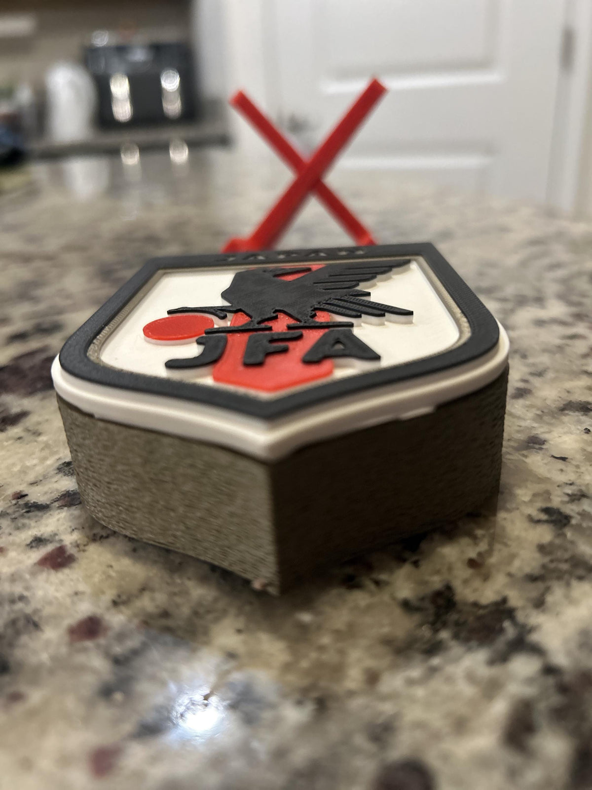 Japan JFA 3D printed shield crest display with red stand and hidden stash box, Samurai Blue soccer fan gift, made in USA