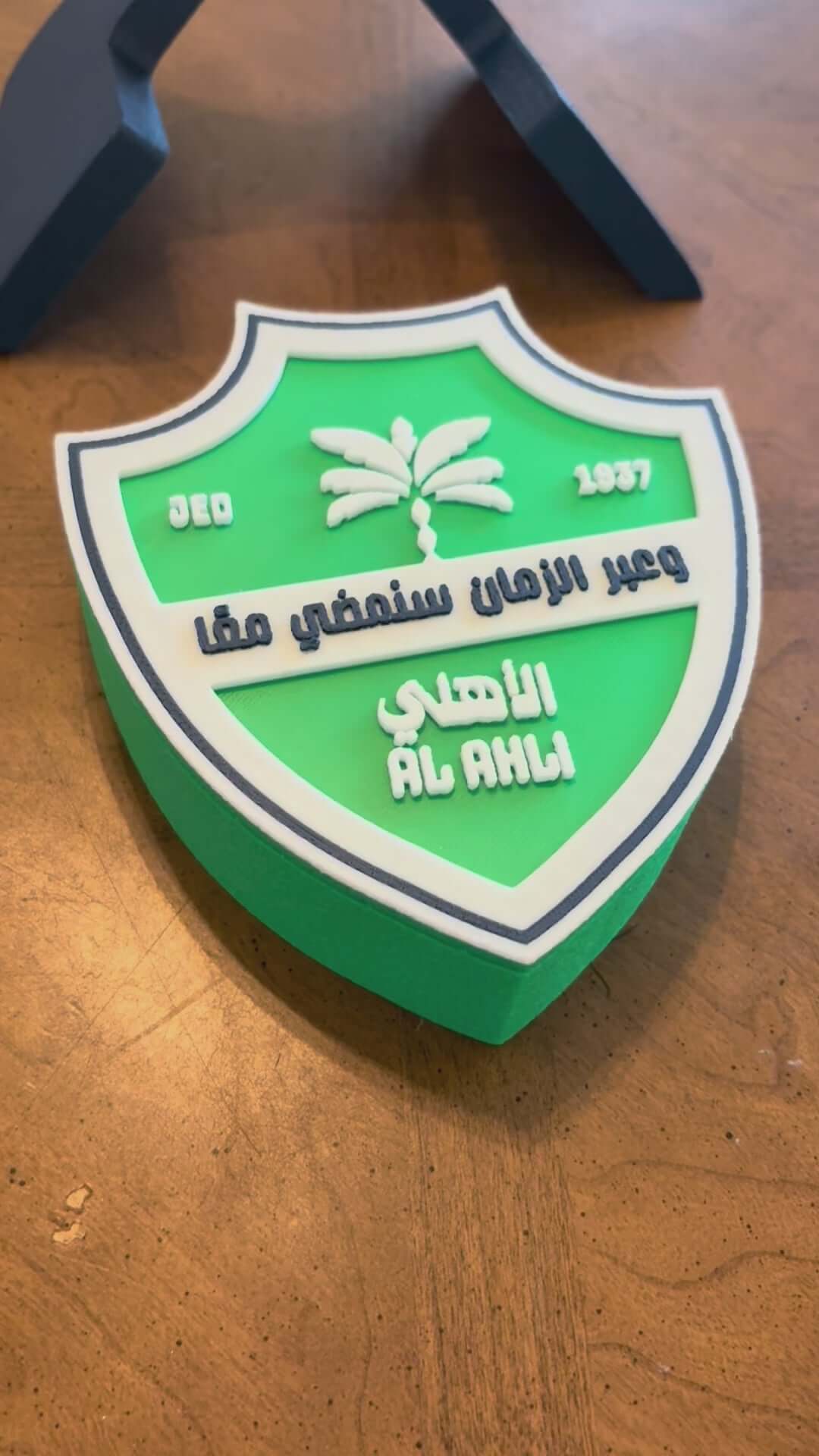 Load video: Vibrant 3D printed Al-Ahli FC plaque showing the team&#39;s crest in green and white, customizable soccer fan decor.