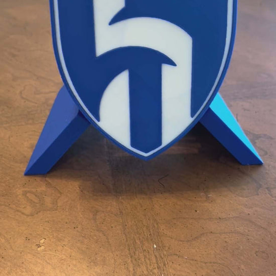 Custom Al Hilal FC 3D printed plaque stands on a wooden surface, showcasing vibrant blue colors and a detailed crest design.