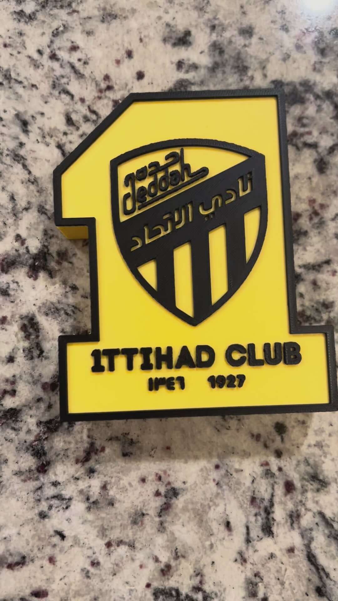 Load video: 3D printed Al-Ittihad Club plaque in vibrant colors, showcasing iconic logo and number one design for passionate fans.
