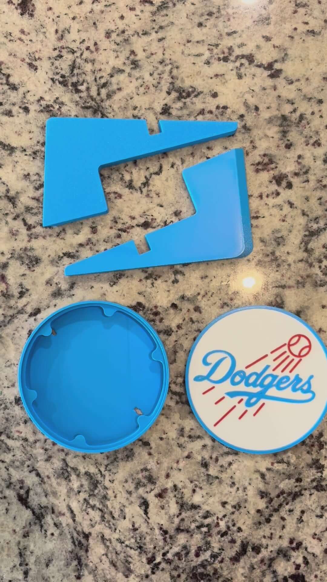 Load video: Customized Los Angeles Dodgers 3D printed plaque pieces in vibrant blue on a marble countertop.
