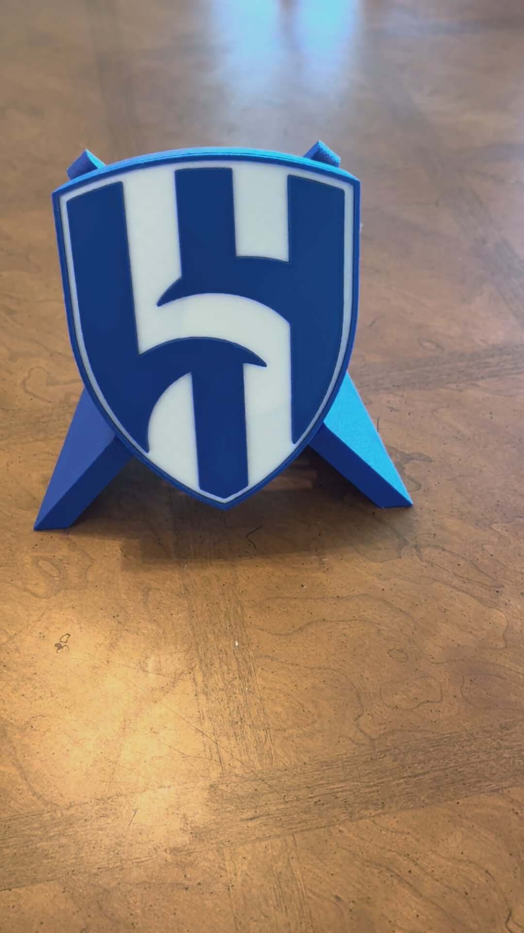 Load video: Al Hilal FC 3D printed plaque showcasing vibrant blue shield design, perfect for soccer fans and unique decor.